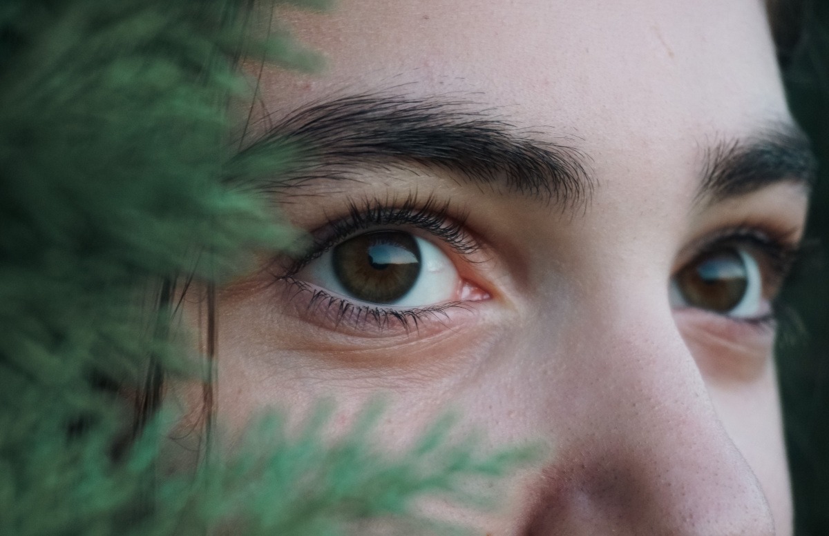 Ojos de una chica joven junto a una planta